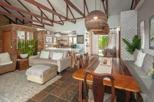 a living room with a table and a couch at Windsong Cottage in Hermanus