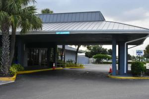 a parking lot with a building with a palm tree at Days Inn by Wyndham Stuart in Stuart