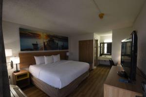 a hotel room with a large bed and a flat screen tv at Days Inn by Wyndham Stuart in Stuart