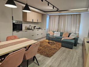 uma cozinha e sala de estar com um sofá e uma mesa em Nana Apartaments em Cluj-Napoca