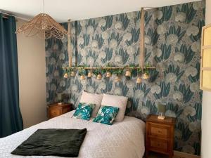 a bedroom with a bed with a green and white wallpaper at Gite de Groupe Aux Instants Partagés in Fontenay-sur-Vègre +37 photos