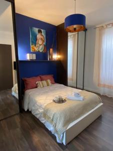 a bedroom with a bed with a blue wall at La crème de la crème - Chantilly in Chantilly