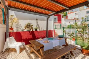 a patio with a table and chairs and a red wall at Algés Village Casa 4 by Lisbon-Coast vacation in Algés