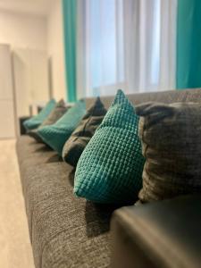 a row of green pillows on a couch at Neuwertiges Apartment mit schnellem WLAN, Glasfaser, Kostenlose Privatparkplatz auch für Transporter geeignet R25 in Freiberg am Neckar