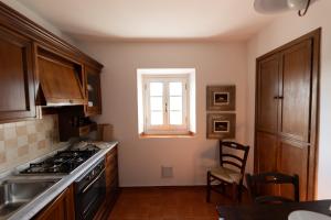 cocina con fogones y ventana en Borgo di Porciano Casa Maggiolino, en Stia