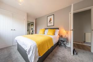 a bedroom with a large bed with yellow pillows at The Saltings in Heacham