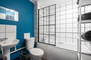 a bathroom with a white toilet and a sink at Maidstone Central Studio Apartment in Kent