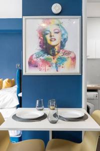 una mesa con dos vasos y una foto de una mujer en Studio Apartment in Central Maidstone, en Kent