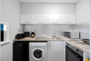 a kitchen with a washing machine and a sink at Studio Apartment in Central Maidstone in Kent