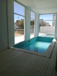 ein leeres Zimmer mit einem Pool mit Fenstern in der Unterkunft Carpe Diem Monte Hermoso in Monte Hermoso