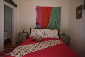 1 dormitorio con 1 cama roja y 2 mesitas de noche en Sto Dimeiko, en Krionérion