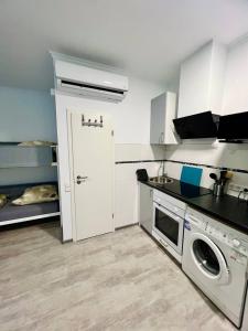 eine Küche mit Waschmaschine und ein Bett in einem Zimmer in der Unterkunft Neuwertiges Apartment mit schnellem WLAN, Glasfaser, Kostenlose Privatparkplatz auch für Transporter geeignet R25 in Freiberg am Neckar
