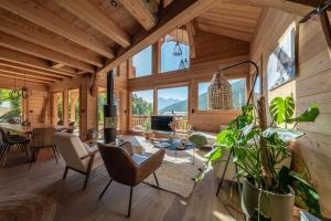 a living room with wooden walls and large windows at Chalet Ski Académie - Serre Chevalier in Saint-Chaffrey