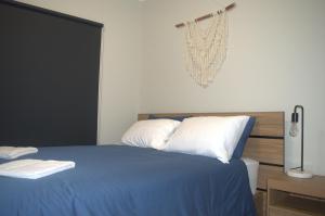 1 dormitorio con 1 cama con sábanas azules y almohadas blancas en Modern Apartment in Roxby Downs, en Roxby Downs