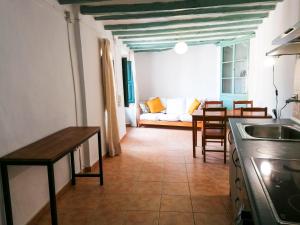 Vila Closa Juncosa في Juncosa: مطبخ وغرفة معيشة مع أريكة وطاولة