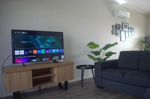 sala de estar con TV y sofá en Modern Apartment in Roxby Downs, en Roxby Downs