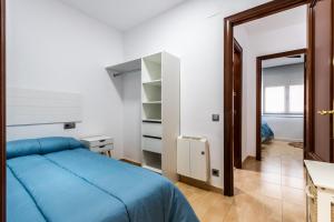 a bedroom with a blue bed and a mirror at BALARI in Sabadell
