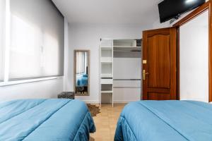a bedroom with two beds and a wooden door at BALARI in Sabadell