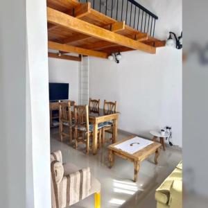 een woonkamer met een houten tafel en stoelen bij Zorzal Tempo in Esquel