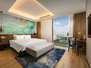 a hotel room with a bed and a large window at Mövenpick Living West Hanoi in Hanoi