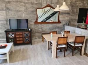 uma sala de jantar com uma mesa e uma televisão em rural loft with pool views peaceful place near the center em Málaga
