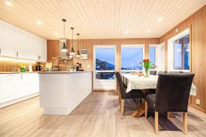 a kitchen and dining room with a table and chairs at Beautiful mountain View Cabin in Lofoten in Pettvik