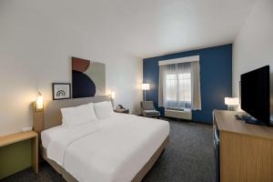 a hotel room with a bed and a flat screen tv at Spark by Hilton Midland South in Midland