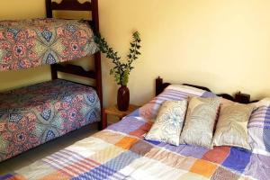 1 Schlafzimmer mit 2 Etagenbetten und einer Vase in der Unterkunft Local privilegiado em Aguas ! in Águas de Lindóia