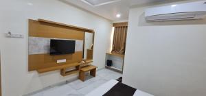 a room with a flat screen tv on a wall at Hotel Vivan in Vadodara