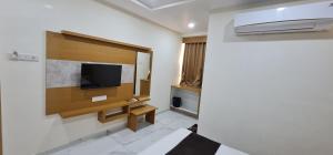 巴罗达Hotel Vivan的墙上配有平面电视的房间