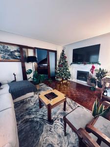 een woonkamer met een kerstboom en een bank bij Beautiful ocean view home in Paço de Arcos