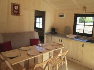 comedor con mesa y sillas en la cocina en Camping la Borie Basse, en Condat
