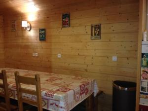 Cette chambre dispose d'une table et d'un mur en bois. dans l'établissement Les Campanules - Demi-chalet au pied des pistes, à Saint-Gervais-les-Bains