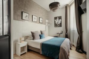 パリにあるオテル ダアルジャンソンのベッドルーム1室(青い毛布付きのベッド1台付)