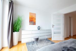 a bedroom with a white dresser and a chair at FeWo 03 im Carré Charlott in Pulsnitz