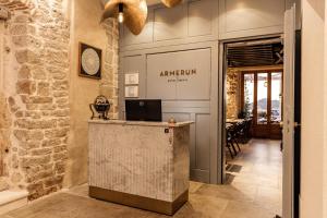 a hotel lobby with a counter and a dining room at Armerun Heritage Hotel & Residences in Šibenik