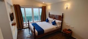 科塔吉里COASTAL GRAND RESORT - KOTAGIRI的一间带床和大窗户的卧室