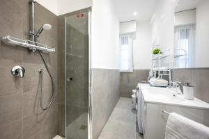 uma casa de banho com um chuveiro e um lavatório. em All in One Parma em Parma