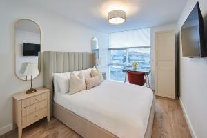 a bedroom with a bed with a mirror and a window at Host & Stay - The Municipal View Abode in Liverpool