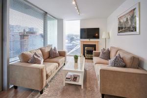 a living room with two couches and a large window at Host & Stay - The Municipal View Abode in Liverpool