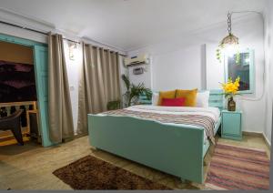 um quarto com uma cama azul com almofadas coloridas em TTH em Goa Velha