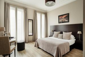 a hotel room with a bed and a chair and windows at Hôtel d'Argenson in Paris