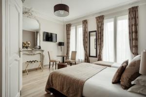 Habitación de hotel con cama, mesa y sillas en Hôtel d'Argenson, en París