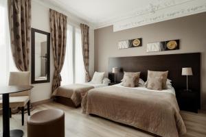 巴黎的住宿－阿爾根松酒店，一间卧室配有两张床、一张桌子和一面镜子