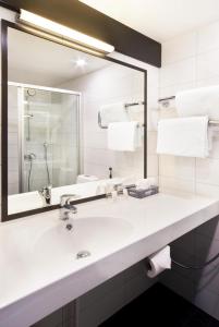 W łazience znajduje się umywalka i lustro. w obiekcie Original Sokos Hotel Vaakuna Hämeenlinna w mieście Hämeenlinna