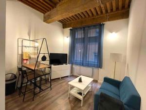 ein Wohnzimmer mit einem blauen Sofa und einem Tisch in der Unterkunft Petit Marin Hyper centre in Lyon + 5 Fotos