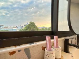 a bathroom with three toothbrushes in holders in front of a window at Casa de Jumbo in Anping