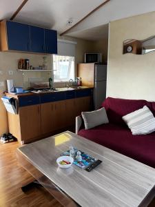 ein Wohnzimmer mit einem Tisch und einer Küche in der Unterkunft mobil-home 4/6 pers in Les Moutiers-les-Mauxfaits