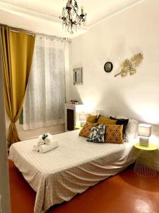 ein Schlafzimmer mit einem Bett mit Kissen und einem Fenster in der Unterkunft Magenta - T2 Au Cœur Du Carré D'or De Nice in Nizza