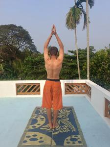 a man standing on a mat with his hands in the air at Paddy N Canal Homestay in Alleppey